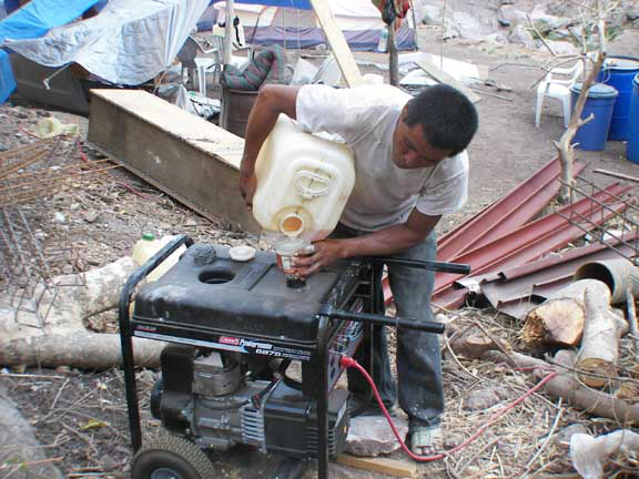 Chaleo filling the generator that runs the cement mixer