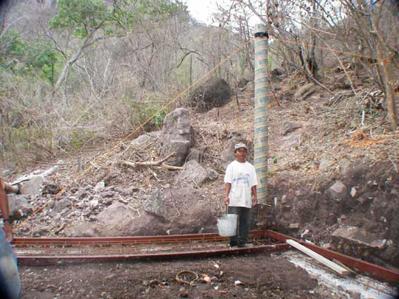 Librado preparing to pour the first bucket of concrete