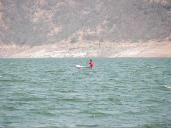 Neighbor in a small canoe leaving campamento agua fria after filling up his water jugs